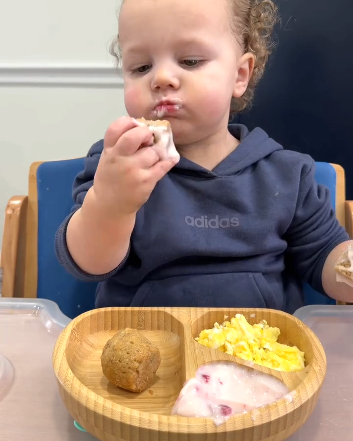 Enfant dégustant son repas dans une assiette adaptée