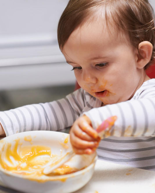 Bébé explorant son repas avec les mains